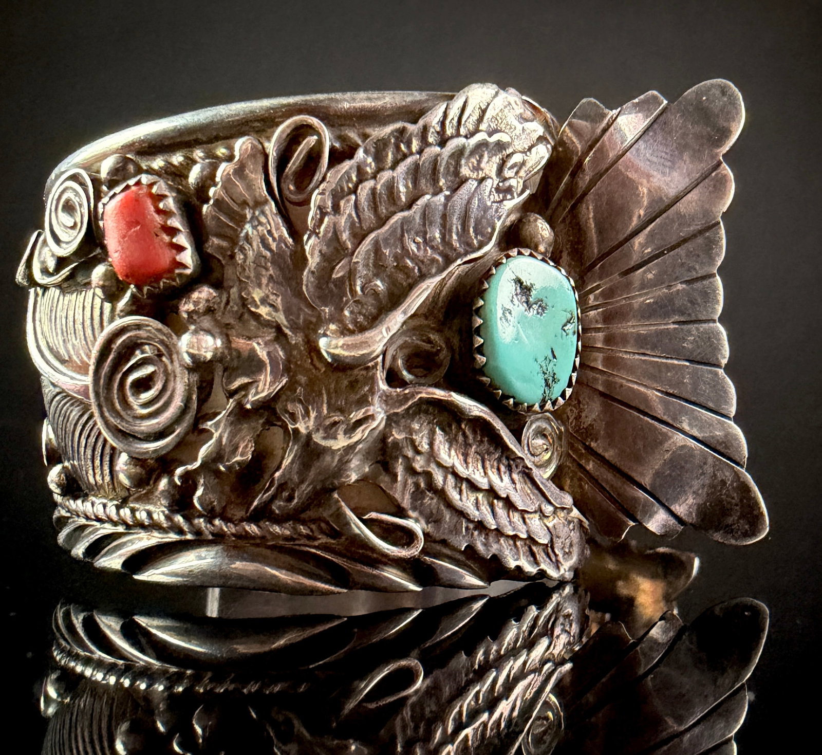 Allan Chee Navajo Sterling Silver Eagle Motif Cuff Bracelet with Turquoise and Coral: A Navajo sterling silver cuff bracelet featuring elaborate three-dimensional applique work. The central design consists of an eagle rendered with outstretched wings, including a distinct, separate