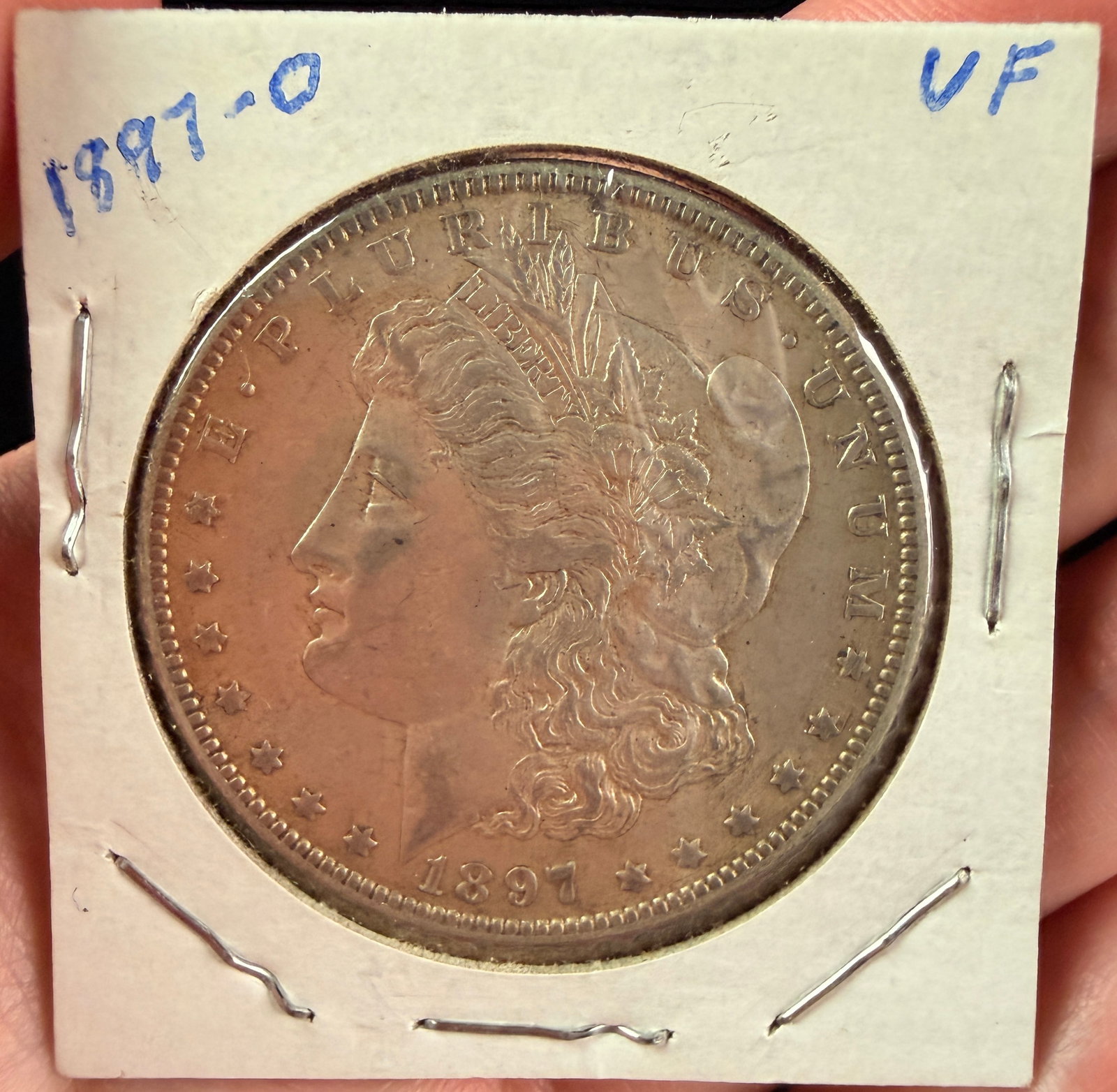 US 1897-O Morgan Silver Dollar: A US 1897-O Morgan silver dollar struck at the New Orleans Mint. The coin is composed of 90% silver and 10% copper. The obverse displays the Morgan design and the date 1897. The reverse includes the