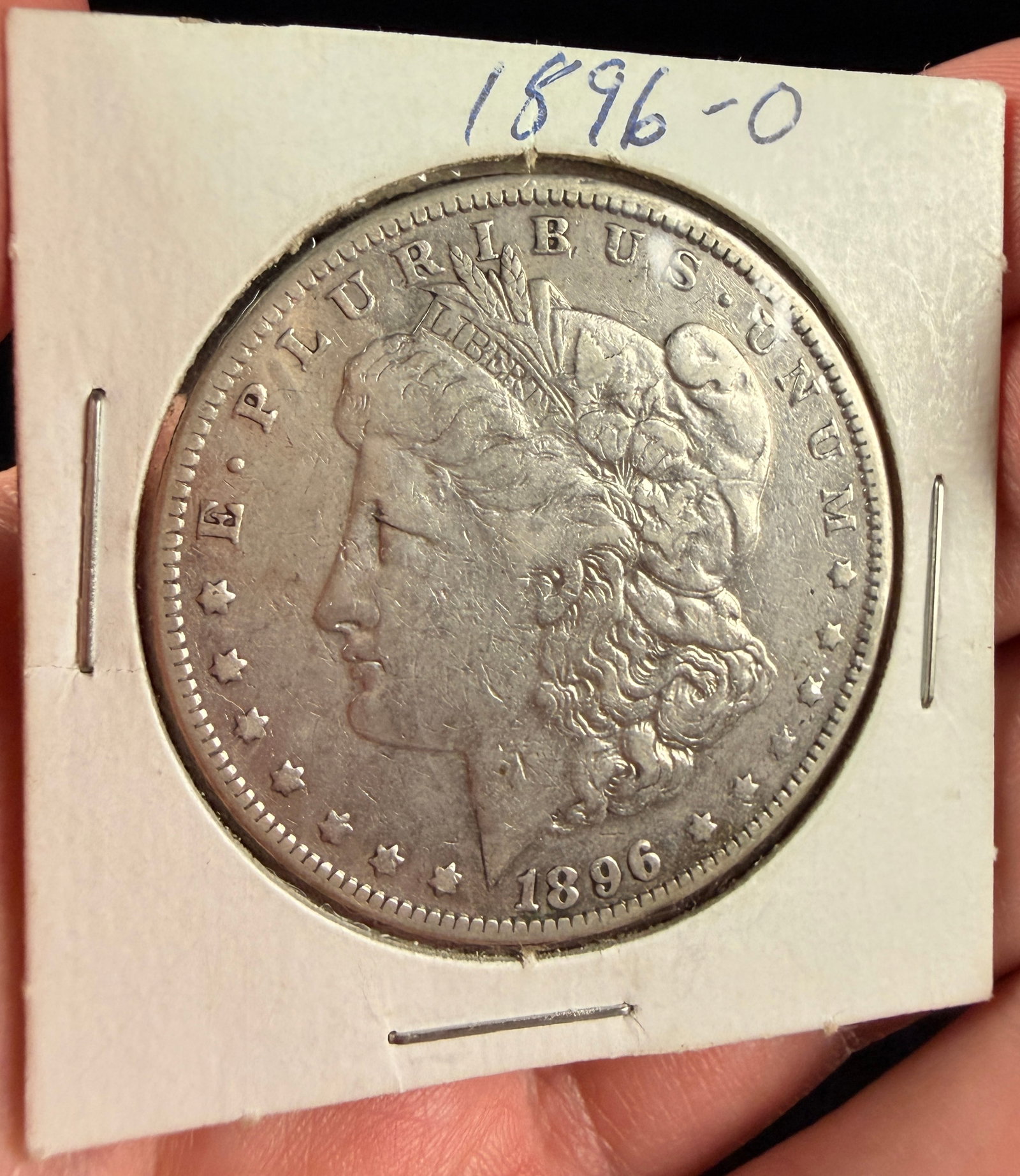 US 1896-O Silver One Dollar Coin: A US silver one dollar coin struck at the New Orleans Mint, dated 1896. The obverse features the legend E PLURIBUS UNUM above the date 1896, with thirteen stars along the periphery. A headband is