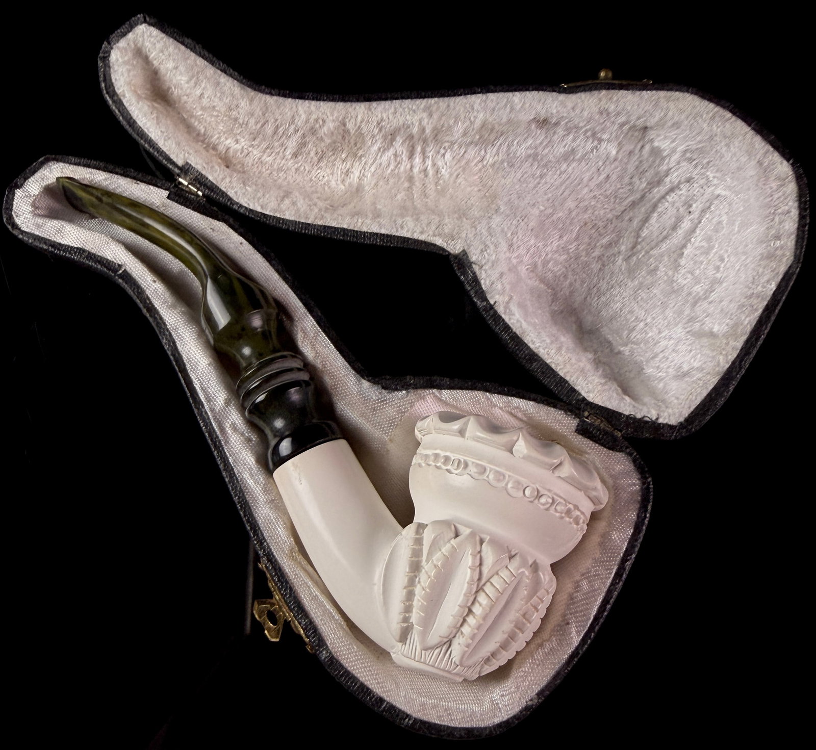 Carved Meerschaum Smoking Pipe with Mottled Green Stem and Fitted Case: A hand-carved meerschaum tobacco smoking pipe accompanied by its original fitted presentation case. The bowl is sculpted with a crown-like scalloped rim above a band of circular relief carvings,