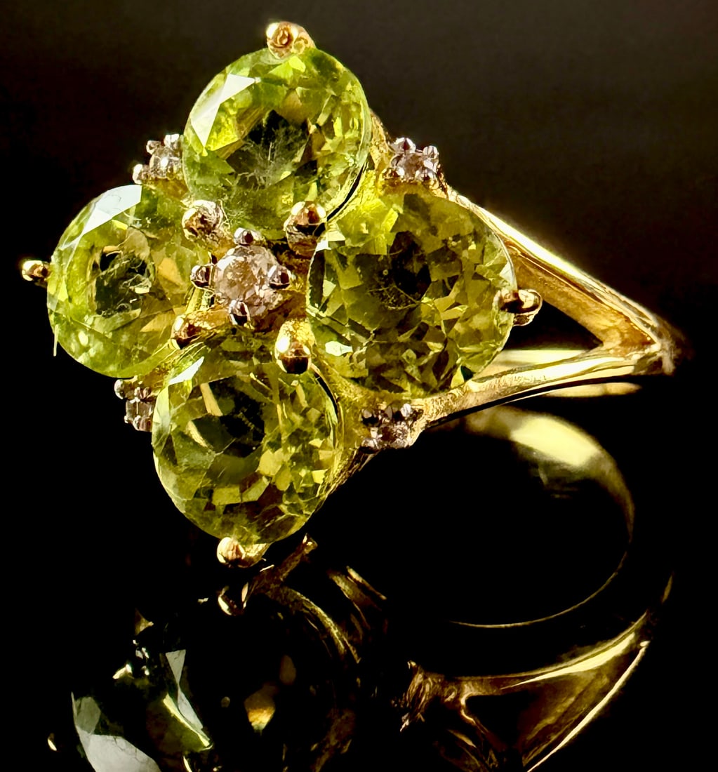 Annabella Collection Gold Flash Sterling Silver Hunan Peridot and White Topaz Floral Motif Ring: This ring from the Annabella collection is crafted in gold-flash sterling silver and features a floral design. The setting holds four round-cut Hunan peridots arranged as petals around a central round