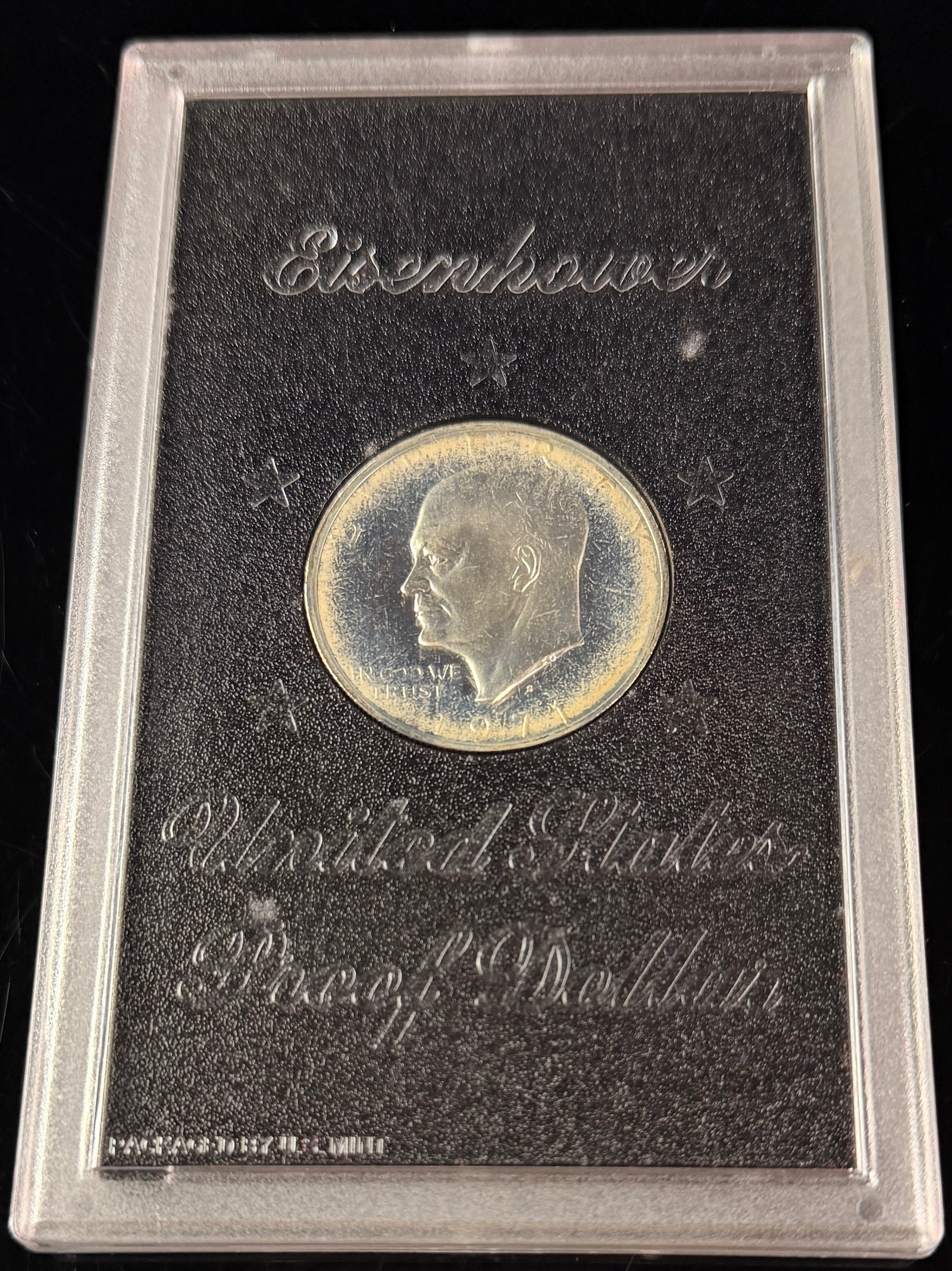 1971-S US Eisenhower 40% Silver Proof Dollar in US Mint Packaging: A 1971-S US Eisenhower dollar, struck in 40% silver. This proof specimen is housed in its original hard black plastic presentation holder. The obverse features the Eisenhower portrait type with the S 