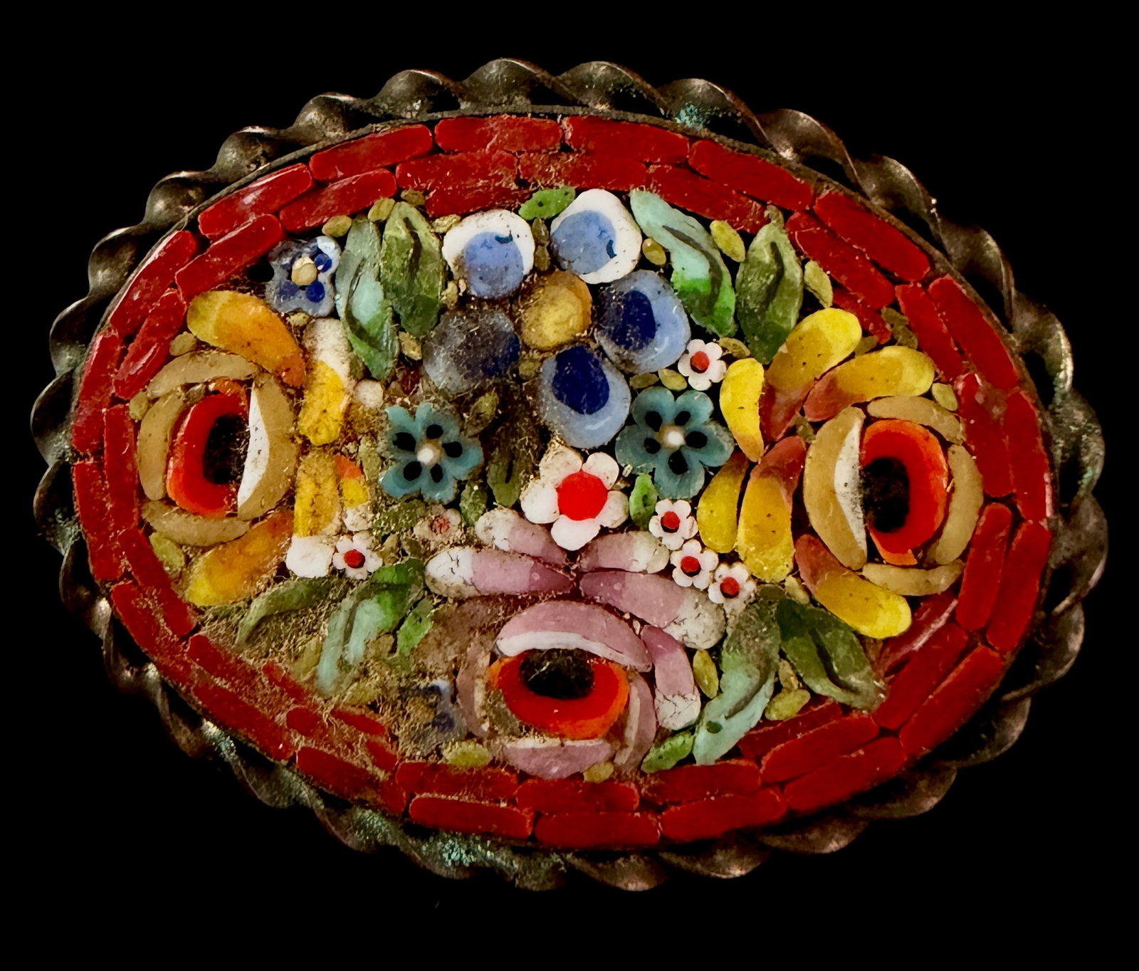 Italian Micro Mosaic Floral Brooch: An Italian micro mosaic floral brooch featuring a central bouquet of stylized blossoms. The design is constructed from multi-colored glass tesserae in shades of blue, yellow, pink, and white with gree