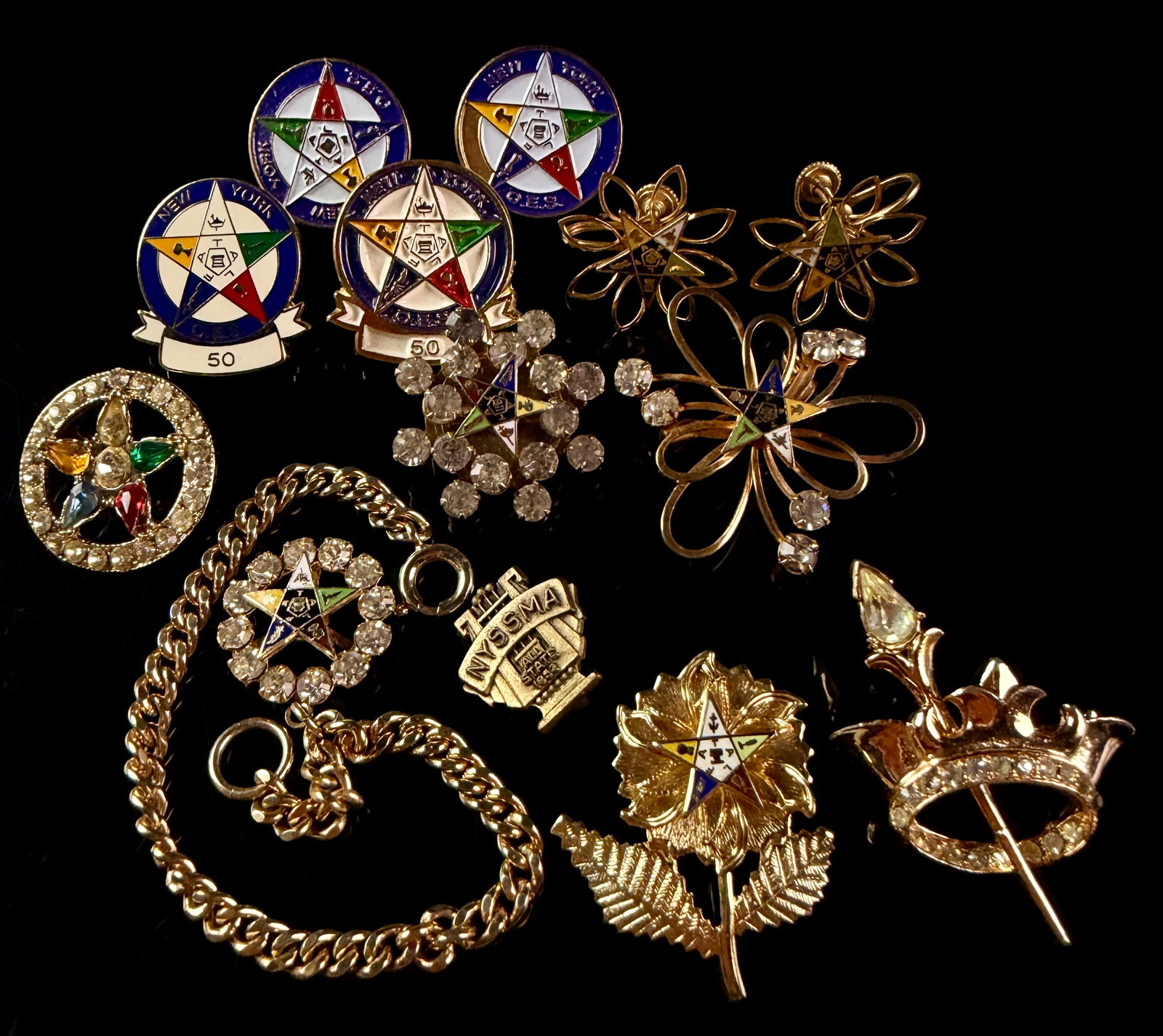 A Collection of Vintage Order of the Eastern Star Jewelry and a 1953 NYSSMA Pin: A group of mid-20th-century gold-tone fraternal and organizational jewelry. The collection primarily focuses on the Order of the Eastern Star (OES) and includes four circular enamel lapel pins featuri