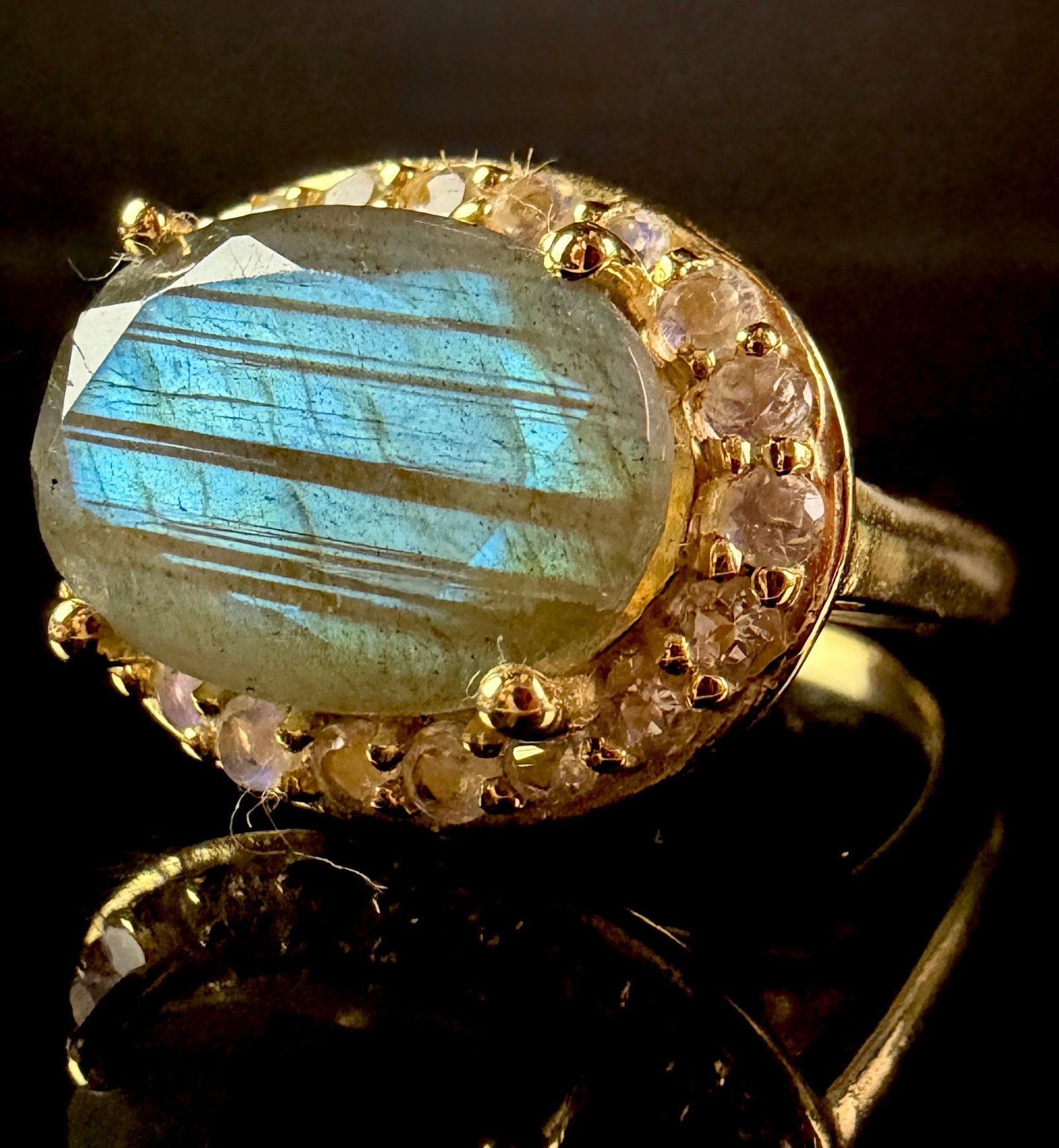 Annabella Collection Labradorite and Rainbow Moonstone Halo Ring in Gold Flashed Sterling Silver: A cocktail halo ring featuring a large oval-cut labradorite center stone displaying characteristic blue labradorescence and parallel banding. The center stone is surrounded by a border of twenty