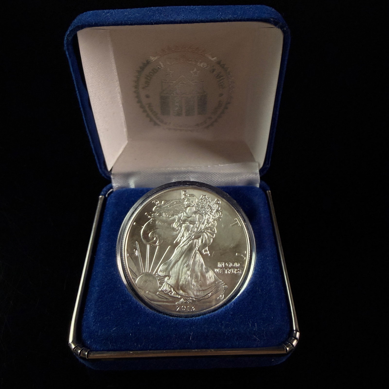 US 2013 American Silver Eagle One Dollar 1 oz Fine Silver Coin in National Collector's Mint Box: This US one dollar denomination bullion coin is struck in one ounce of .999 fine silver. The obverse features the Walking Liberty design with inscriptions reading L I B E R T Y, IN GOD WE TRUST, and t