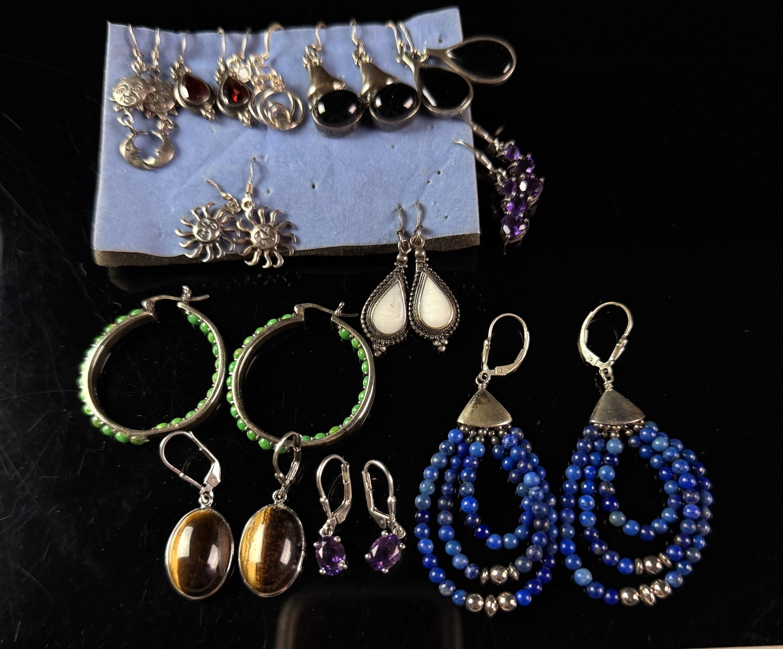 A Sterling Silver and Gemstone Earring Lot: This lot consists of an assortment of sterling silver earrings featuring a variety of natural gemstones and decorative motifs. Included in the collection is a pair of Chinese lapis lazuli earrings fea