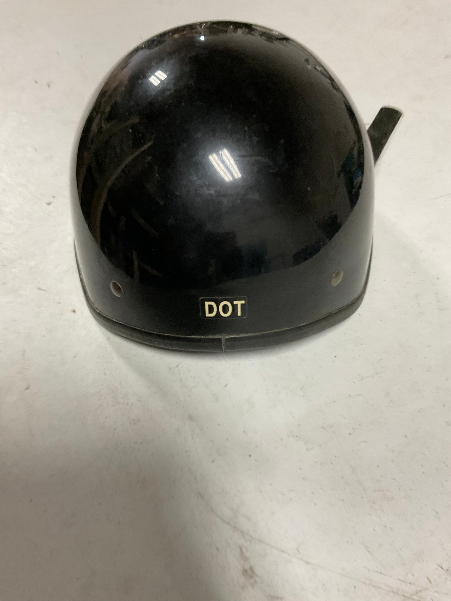 Vega Motorcycle Half-Helmet Gloss Black Size M: A Chinese-made Vega motorcycle half-helmet composed of motorcycle materials. This gloss black helmet features a traditional half-shell profile with two silver-tone rivets on each side. The interior is