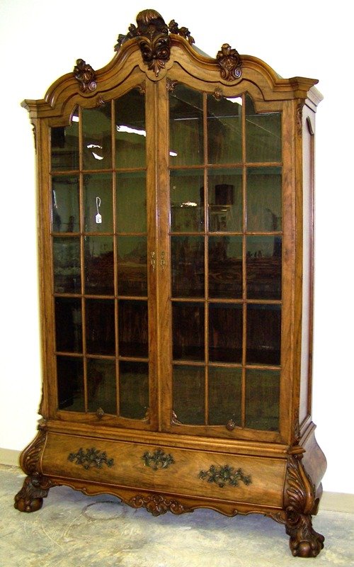 Cuban 20thC Bombay Display Cabinet: Resting on massive carved claw & ball feet and also carved bonnet top. Two doors,Stands app. 8 foot tall,63" wide 19" deep at base.