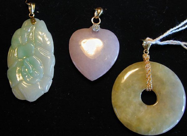3 - 14KT & JADE PENDANTS: a. Lavendar jade heart pendant mounted w/ 1/4ct diamond, 1.5" length. b. Pale green carved jade pendant, floral design, 2" length. c. Pale green round jade disc mounted w/ gold chain, 1.75" length.