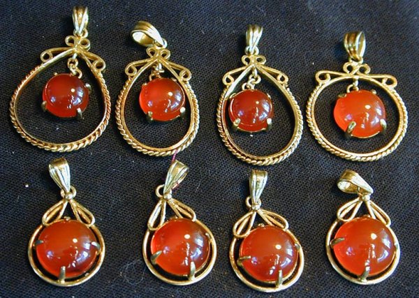 8 CARNELIAN AND STERLING VERMEIL PENDANTS: 4 with half cut 10mm mounted stones, 3/4" length; 3 with half cut 7.5mm stones, 1 1/4" length; 1 with half cut 10mm stone, 1" length.