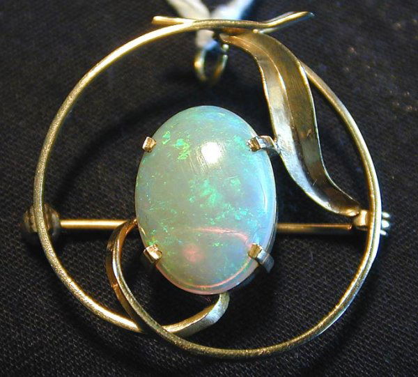 VINTAGE 9KT PIN/PENDANT W/ 4.03CT FIERY OPAL: Circular design with fiery opal mounted within a swirl leaf design, 1.25" diameter, 3.0 dwt.