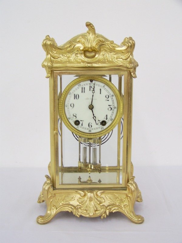 Early Seth Thomas Porc. Face Clock: In a brass ornate case and beveled glass face sides and back.Stands 14 3/8" tall 8" wide at base.