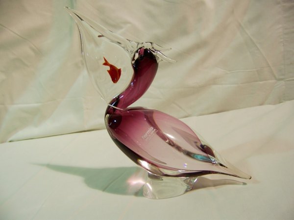Large Signed Formia Pelican W/ Fish in Mouth: Large Signed Formia Peligan W/ Fish in Mouth, body of peligan a purplish color with clear beak and red fish in mouth. Stands app. 12" & app. 10" wide.