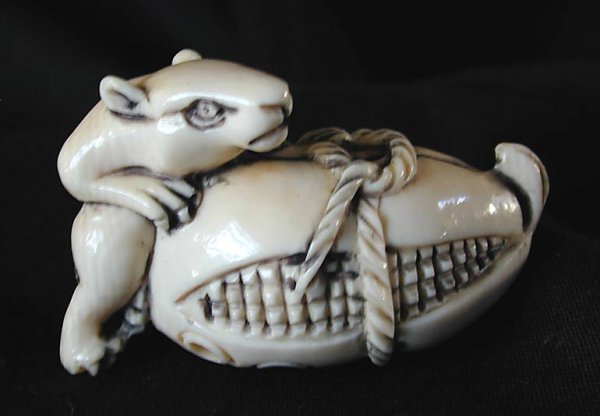 Old Ivory Netsuke signed: This finely carved old ivory netsuke depicting a mouse with an ear of corn is 1 3/4" long with a wood display stand. NOTE: We will not ship this item internationally