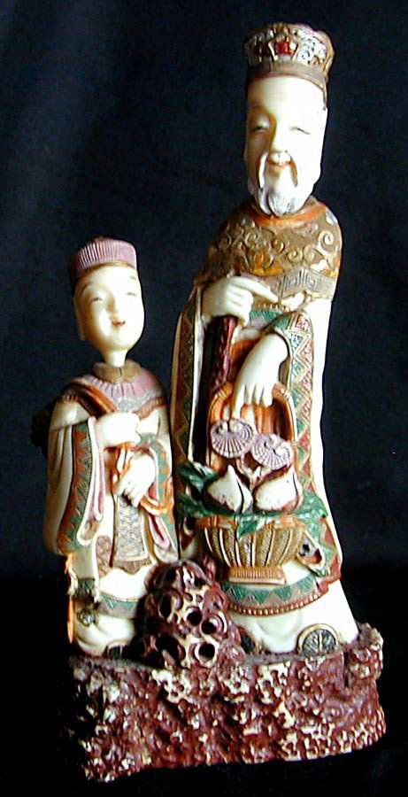 Old Chinese Ivory Double Snuff Bottles: This is a solid Ivory grouping of a father and son. The ivory is polychromed and each figures heads comes off to show stems with spoons. It is 7 1/4" high. Signed on bottom.