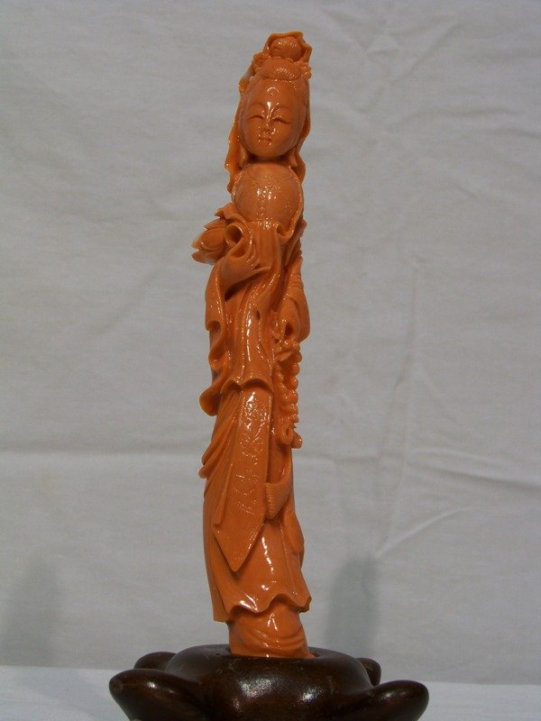 Early Chinese Red Coral Figural Carving of Quanyin: Early Chinese Red Coral Figural Carving of Quanyin or Hsi Wang?? resting in a 4 legged wooden base. Figure is app. 7" long, in base is 7 3/4" tall.