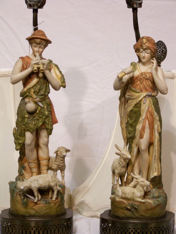 Pair Royal Dux Style Sheep Hearder Porcelain Lamps: Pair Royal Dux Style Sheep Hearder Porcelain / Bisque Lamps. One of male sheep hearder other of female. Both figures are app. 15" tall resting in the metal base of lamp.Base to harp base is 18 1/2" ta