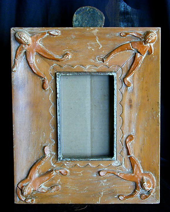 SOUTHWEST FOLK PICTURE FRAME: An artisan designed prototype picture frame made from carved wood with applied ceramic figures to each corner, inner frame and figural stand made of iron, 12"H x 10"W x 9"D.