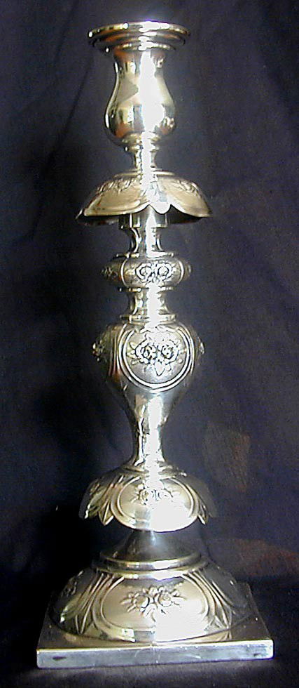 EUROPEAN SILVER CANDLESTICK 13.25"H: A single European silver candlestick with square base and lobed design with embosed floral motif, marked G. Plater 1129, 13.25"H.