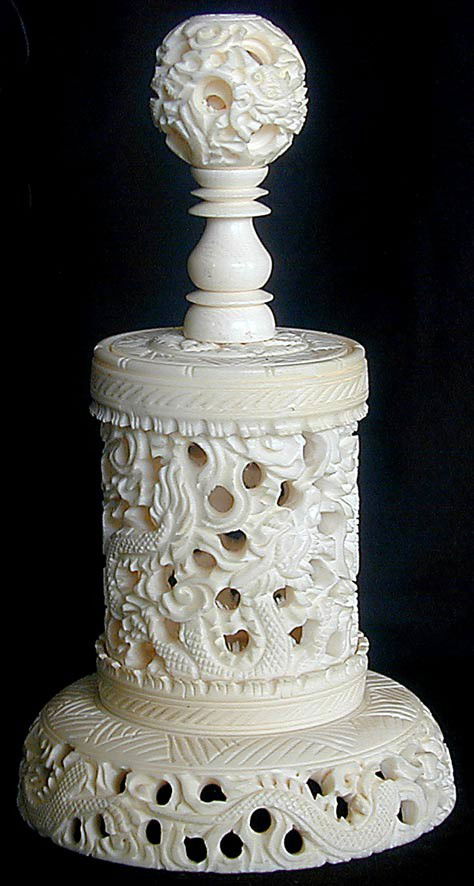CHINESE IVORY MYSTERY BALL DRAGON BOX: A carved and reticulated cylinder box with dragon design, the cover screws on and is mounted with a mystery ball finial, 6"H, good condition. Will not ship international.