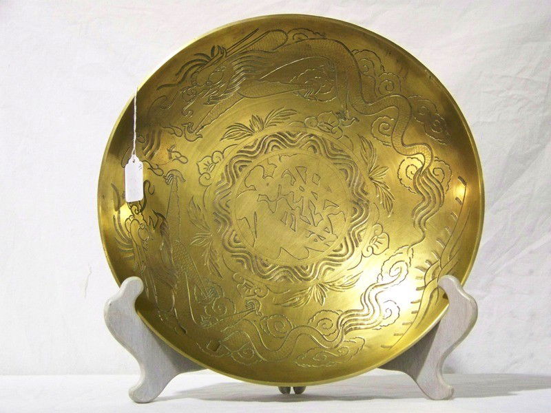 Early Chinese Brass Dueling Dragons 14" Charger: Early Chinese Brass Dueling Dragons 14" Charger. Has large symbol to center of bowl. 14" across and 2 1/2" deep. Looks to of had a handle at one time. Impressed China on bottom.