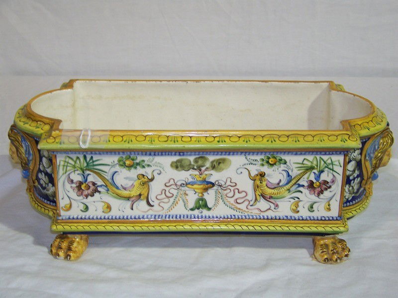 ANTIQUE PORCELAIN CAPODIMONTE PLANTER WITH PAW FEE: ANTIQUE PORCELAIN CAPODIMONTE PLANTER WITH PAW FEET. Great early hand painted claw footed planter with faces on each side.App. 14 1/2" long and 6" wide and 5" tall.