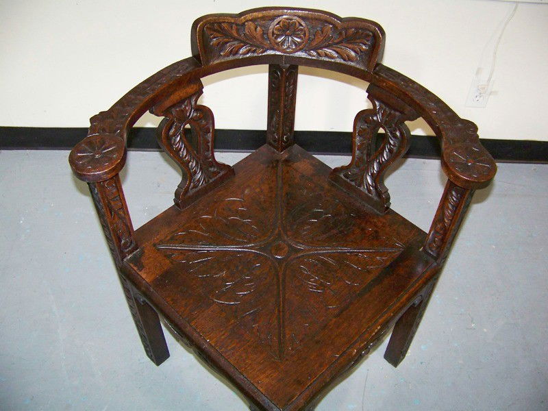 18/19th C. Oak Carved Corner Chair: 18/19 C. Oak Carved Corner Desk Chair has floral carvings on hand rest and back with leaf carvings. Standing 31" tall x 28" wide x 28" deep. with a pierced carved seat.