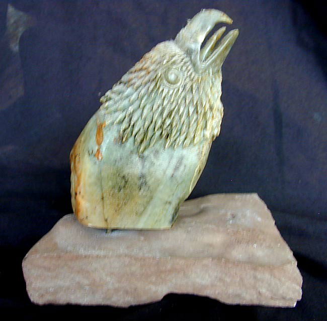 EAGLE STONE TOTEM BY DAVID MARACLE MOHAWK INDIAN: A finely carved stone eagle totem by the world-renowned contemporary Canadian Mohawk Indian sculptor David R. Maracle, the eagles head mounted to a pivoting stem which mounts to a stone base, total he