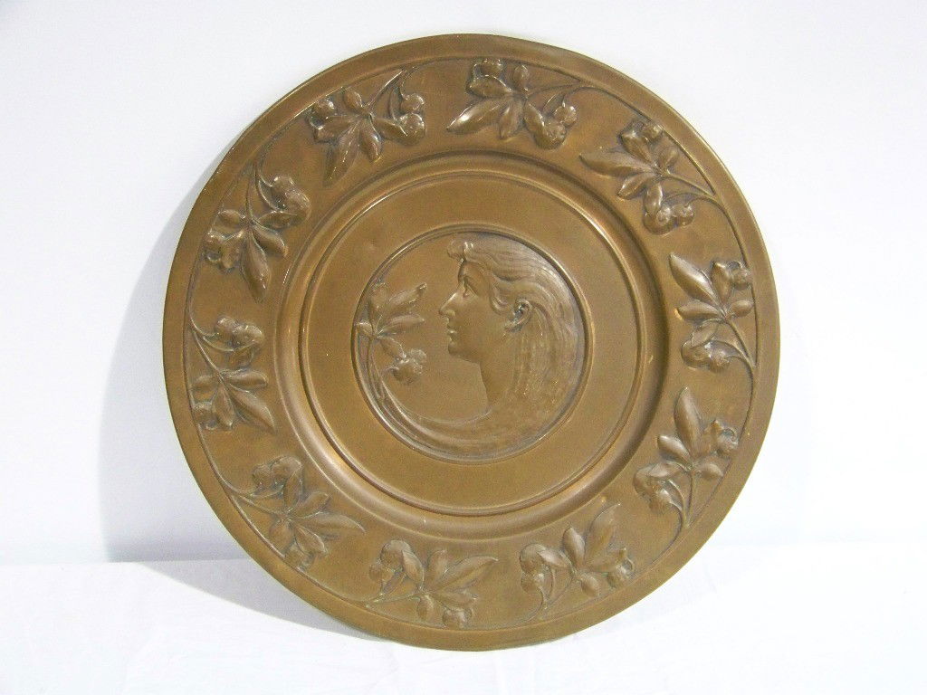 Vintage Copper Art Nouveau Wall Plaque: Vintage Copper Art Nouveau Wall Plaque with a great figure of a lovely Lady smelling a flower. Has a leaf and berry outer boarder.Plaque is app.17" across.