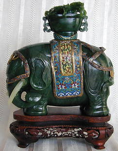 ANTIQUE CHINESE JADE & CLOISONNE ELEPHANT: An antique Chinese jade & cloisonne elephant with cloisonne saddle mounts upon which is a carved jade basket of flowers from which a missing red coral pediment stood; the face of the elephant is also