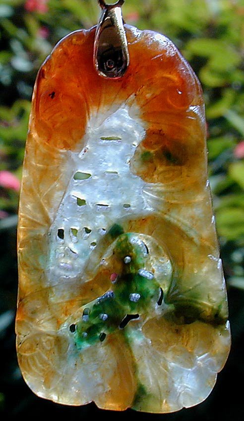 MULTICOLOR CHINESE CARVED JADE BAT PENDANT: Hanging from a gold mount; translucent stone of carved bats, flowers and temple design, 2.25"L x 1"W.