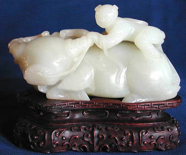 ANTIQUE CHINESE WHITE JADE CARVING: This is a charming antique Chinese white jade carving depicting a young boy riding a water buffalo. It is 5" wide x 3" high. The fine hand carved wooden base is 1 1/2" high. The weight is 20 troy ozs.