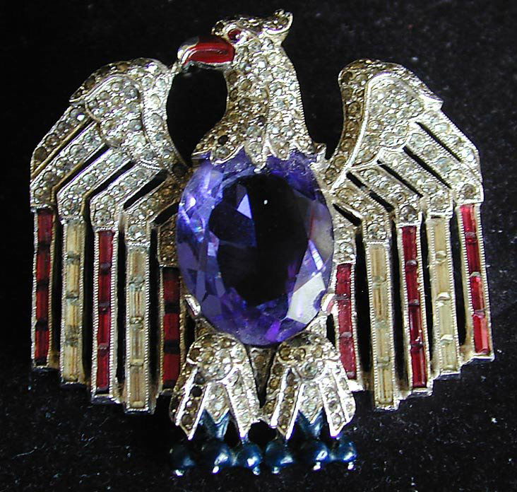 CROWN TRIFARI ALFRED PHILIPPE EAGLE STARS/STRIPES: A fine example of a Crown Trifari circa 1940 WWII patriotic pin designed by ALFRED PHILIPPE; the stars and faux ruby baquette stripes are surrounded by a fully sculpted American eagle with a large ova