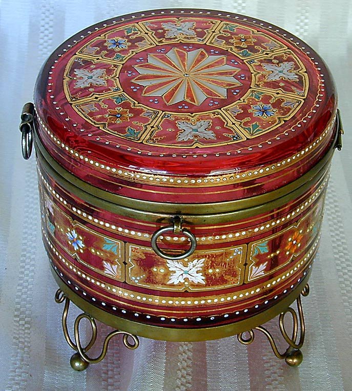 LG. BOHEMIAN CRANBERRY GLASS DRESSER BOX: This is a large Bohemian cranberry glass dresser box. It has very fine enameling and has brass mounts. It has a hinged top. It is 6" high and 7" in diameter and is in very good condition. It has no ch