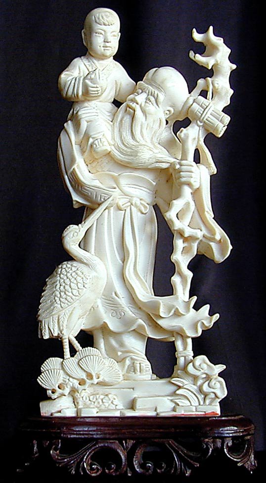 ANTIQUE CHINESE IVORY GROUP 7": This is a fine antique Chinese ivory carving depicting an old sage wth a young boy on his shoulder and a crane at his side. It is 7" high on a 1" carved wood base. It is in very good