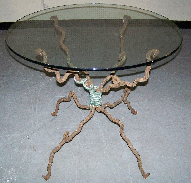 Alana Gore Modern Folk Art Iron Dining Table,Brutalist: Alana Gore Modern Folk Art Iron Dining Table,Brutalist style scrolled base with what looks to be a Snake coiled around base.Base is 30" tall and 33" across base.Has a 36" round glass top. K&M Auction