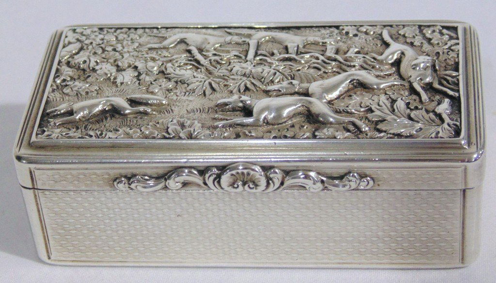 George IV Silver Snuff Box, London 1828 Edward Edwards: A Fine George IV Silver Snuff Box, London 1828 by Edward Edwards II,of oblong form with engine turned base and reeded sides,the hinged cover applied with a plaque cast and chased with a scene of Hound
