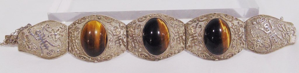Fine Antique Chinese Silver Wire & Tigers Eye Bracelet: Fine Antique Chinese Silver Wire & Tigers Eye Bracelet.Great early Chinese Silver bracelet with Buddhist symbols to each section. Bracelet has four sections with three having a large Tiger's Eye Stone