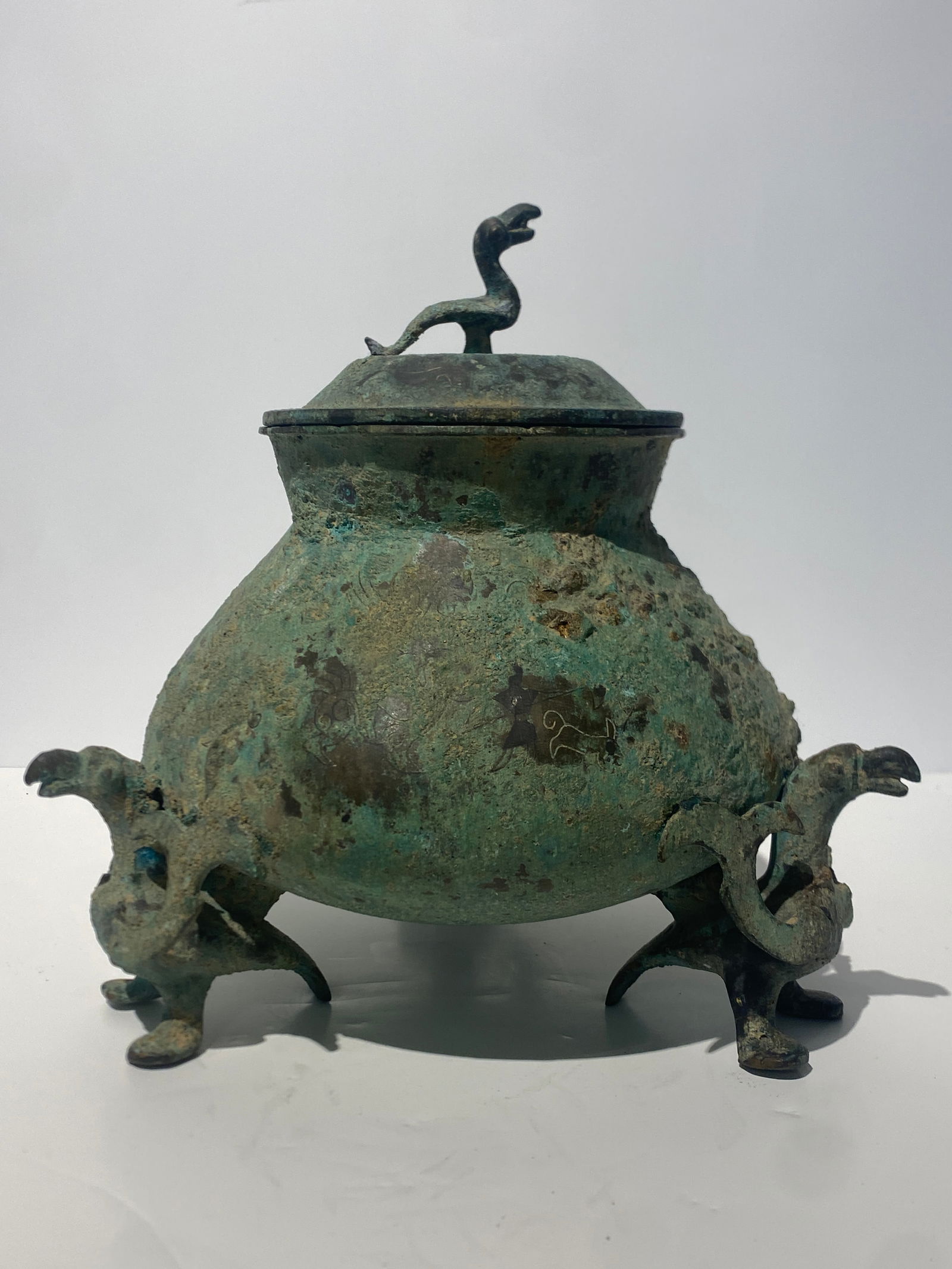Chinese Silver Inlaid Bronze Tripod Vessel with lid Han Dynasty: —-Chinese Silver Inlaid Bronze Tripod Vessel Han Dynasty ——Size is 9” tall with lid.. x aprox 9” wide..Has one wing detached.. see pics..With provenance.. see pics.