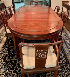 EXCEPTIONAL ROSEWOOD CHINESE DINING TABLE WITH MATCHING CUSTOM CHAIRS: This intricately carved and detailed formal dining room set is imported from China, made of solid Rosewood and is of distinctly Asian influence. The tables' beautiful round edges are intensely regal a