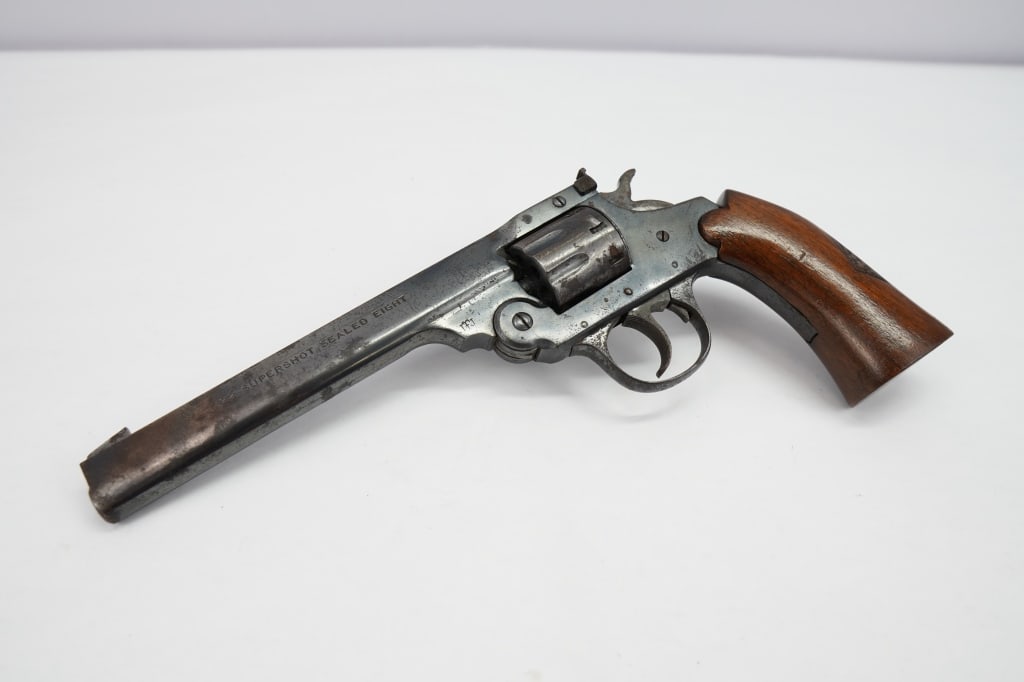 Iver Johnson Arms Supershot Sealed Eight 0.22: This break open rimfire revolver is an Iver Johnson Supershot Sealed Eight chambered in .22 LR. It has a fixed blade front sight, a square notch rear sight, an eight round cylinder, a color case-harde