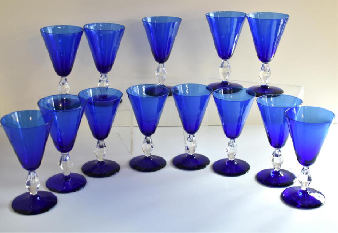 THIRTEEN COBALT BLUE GLASS FOOTED WINE GOBLETS: Each wine glass features a clear faceted stem and measures 5Â¼" tall x 2Â¾" across. Glassware appears to be in very nice overall condition.