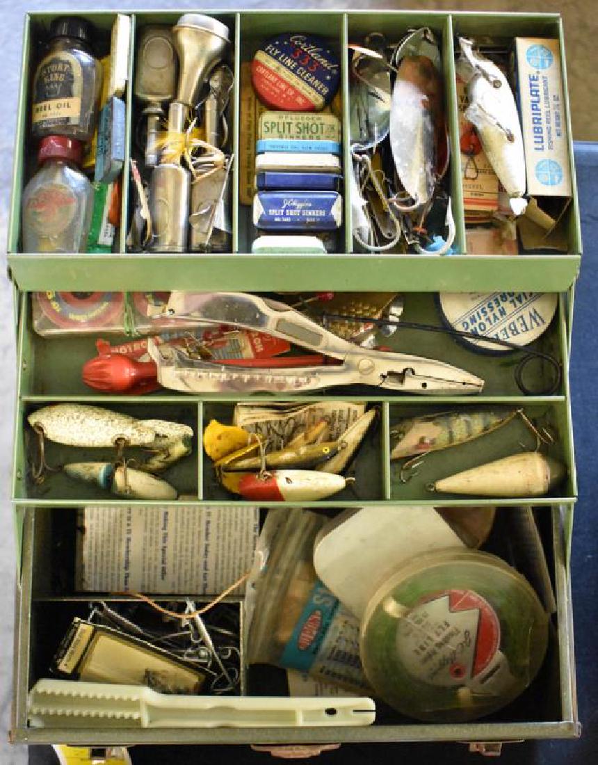 VINTAGE FISHING TACKLE: Vintage tackle box is filled with assorted fishing supplies including lures, line, hooks, and more.