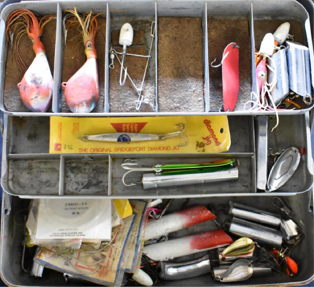 VINTAGE FISHING TACKLE: Vintage tackle box is filled with assorted fishing supplies including lures, line, hooks, and more.