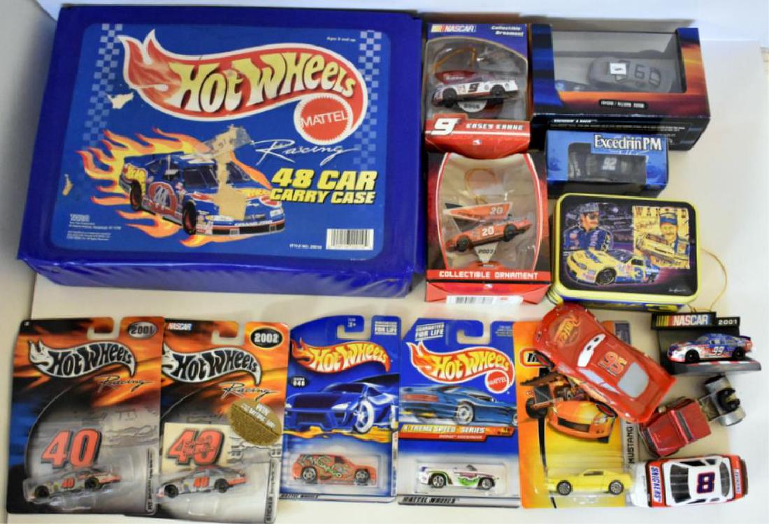 ASSORTED DIE CAST CARS AND MORE: Includes fourteen toy cars in original packaging with NASCAR ornaments, Hot Wheels and more as well as a 48-car Hot Wheel carrying case with 21 die cast cars inside.