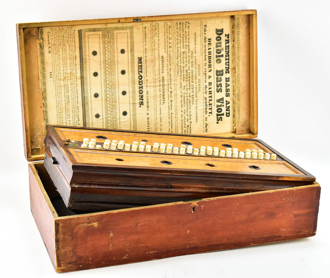 ANTIQUE CHARLES AUSTIN FOR DEARBORN & BARTLETT MELODION OR LAP ORGAN: An antique Charles Austin for Dearborn & Bartlett melodion or lap organ made in the late 1800s with a fitted carrying box, burlwood and birds-eye maple veneer, and functioning bellows.