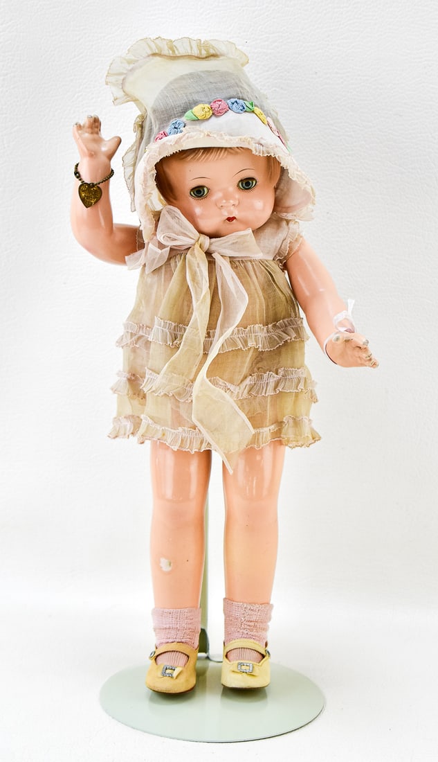 EFFANBEE PATSY ANN DOLL: Effanbee Patsy Ann doll with pink party dress, bonnet, and metal heart bracelet. Circa 1920s. Measures 18" tall.