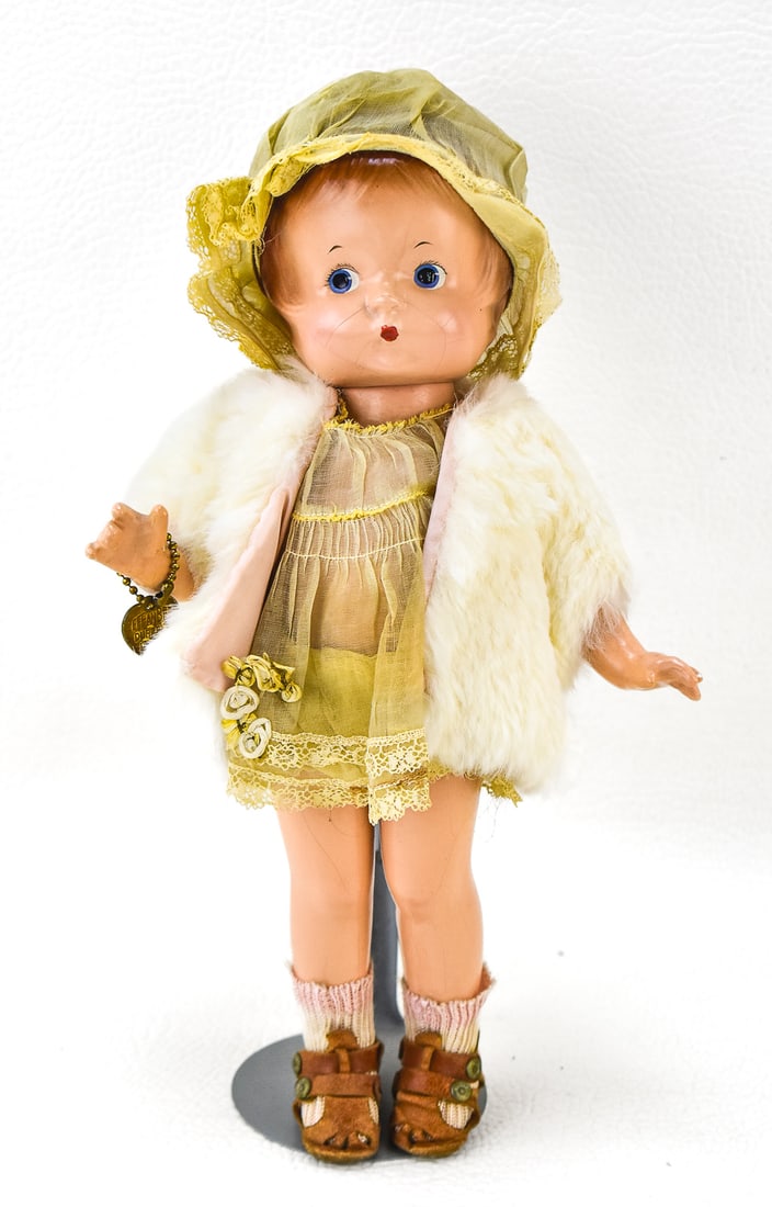 EFFANBEE PATSY JR. DOLL: Patsy Jr. doll in original party dress and fur coat, wearing the Effanbee Durable Dolls heart bracelet. Measures 12" tall. Circa 1930s.