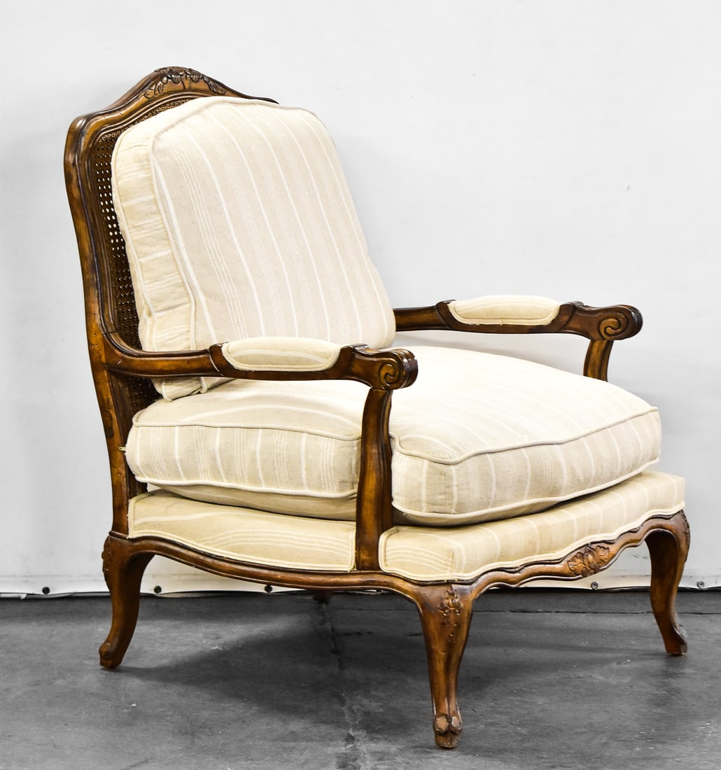 CONTEMPORARY LOUIS XV STYLE BERGERE ARMCHAIR: A contemporary Louis XV style Bergere armchair with caned back and striped ivory upholstery.